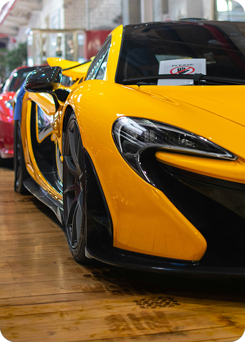 A right close up of a yellow Mercedes AMG sports car headlight on a city street