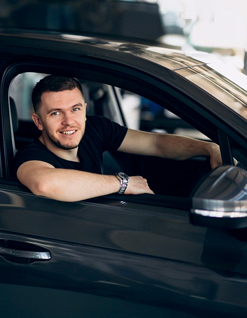 A right close up of a yellow Mercedes AMG sports car headlight on a city street
