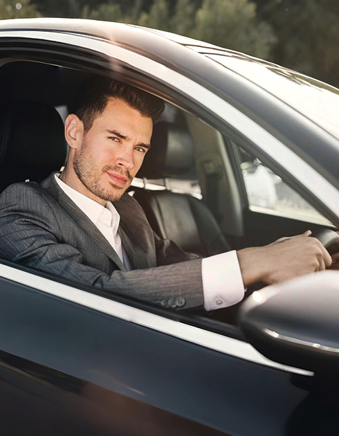 A right close up of a yellow Mercedes AMG sports car headlight on a city street