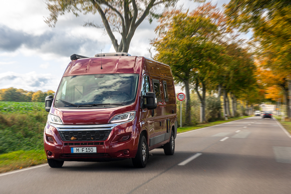 A right close up of a yellow Mercedes AMG sports car headlight on a city street