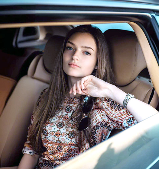A right close up of a yellow Mercedes AMG sports car headlight on a city street